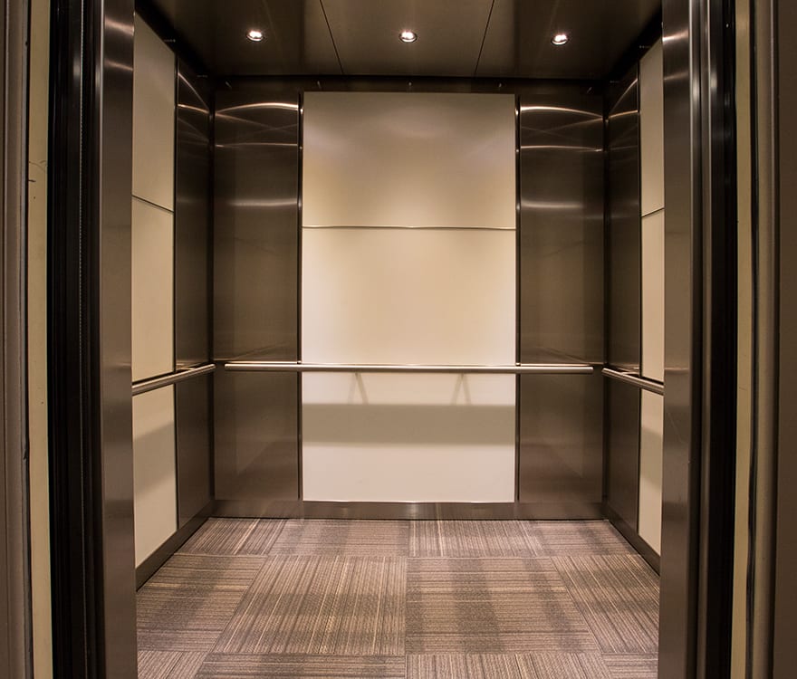 Custom laminated glass elevator cabs in the 6402 Arlington Boulevard elevator