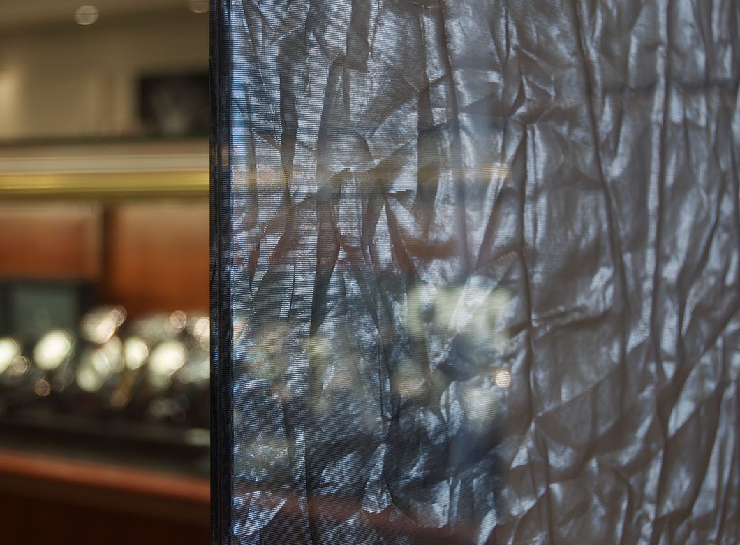 Archetype Glass' innovative glass lamination technology allows for a wrinkled fabric effect in this custom glass partition wall